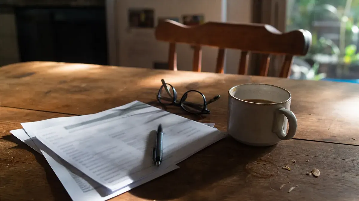 Household loan paperwork spread across a kitchen table for a refinance review